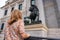 Woman with her back turned in front of the statue of lions in the Congress of Deputies in Madrid, Spain.