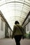 Woman on her back walking in a gloomy and abandoned old and dilapidated building in a poor neighborhood in Europe