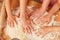 Woman with her children kneading dough in kitchen