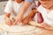 Woman with her children kneading dough in kitchen