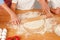 Woman with her children kneading dough in kitchen