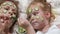A woman with her daughter makes fun of cucumber masks at home