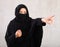 woman with her face covered by burka points her hand to side