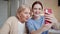 A woman and her grandmother pose for a selfie. They smile and flirt with the camera. Then they look at the resulting