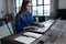 Woman with her hands on laptop keyboard. Designer sitting at worktable with notebook and computer on it.