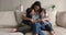 Woman and her kids sit on sofa pose on camera