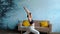 Woman in her living room in warrior yoga pose.