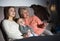 Woman with her mother and son are watching film in time evening rest