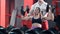 Woman with her personal trainer in the gym exercising with barbells