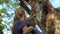 Woman and her son feed a giraffe in a safari park