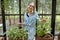 Woman with herbs and flowers in the greenhouse