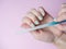 A woman herself is filing her nails with a nail file on her hand on a pink background. Hand nail care at home. Beauty and Health