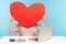 Woman hiding face behind huge red paper heart, symbol of love, romantic feelings, using anonymous dating service