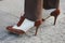 Woman with high heel english brown and white leather shoes before Giorgio Armani fashion show, Milan Fashion