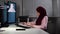 Woman in hijab at work in office sitting at computer and typed on keyboard with concentrated face.