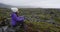 Woman on hike resting on rock hiking on Iceland - Tourist hiker enjoying view