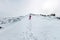 Woman hikeing in the snowy mountains with a phone and snowshoes. and backpack