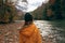 woman hiker admires nature in the mountains autumn river