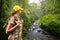 Woman hiker with backpack standing and enjoying rain forest and