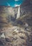 Woman hiker with backpack standing near Vettisfossen waterfall.