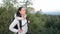 Woman hiker with backpack on top of a mountain enjoying valley view during sunrise