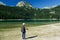 Woman hiker with a backpack and walking stick on the Black Lake