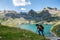 Woman hiker climbing a slope, Lake Estaens in the background