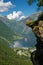 Woman hiker enjoying scenic landscapes at a cliff edge, Geirangerfjord