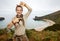 Woman hiker framing with hands in front of ocean view landscape