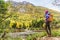 Woman hiker hiking looking at scenic view of fall foliage mountain landscape . Adventure travel outdoors person standing relaxing