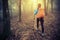 Woman hiker hiking in spring foggy forest trail