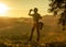 Woman hiker looking into the distance through binoculars