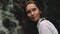 Woman hiker near splashing waterfall portrait