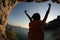 Woman hiker open arms at sunset seaside