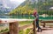 Woman hiker rests on a wooden railing, facing Lake Bries