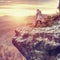 Woman hiker set tripod with camera on exposed rocky summit