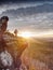 Woman hiker set tripod with camera on exposed rocky summit