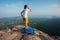 Woman hiker shouting on mountain peak cliff