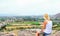 Woman hiker sits on top of a mountain and relaxes while eating an apple