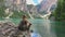 Woman hiker sitts on a cliff near Lago di Braies