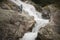 Woman hiker standing on boulder near strong river stream in High Tatras