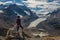 Woman hiker standing on Wilcox peak looking out over the Columbia icefields and the Athabasca Glacier, in Jasper, Alberta, Canada