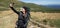 woman hiker stands on the top of the mountain, holds a phone in her hands and makes a video call. Baner.