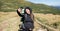 woman hiker stands on the top of the mountain, holds a phone in her hands and takes a selfie on her smartphone. Baner.