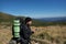 woman hiker stands on the top of the mountain, holds the phone in her hands and types a message. Baner.