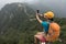 Woman hiker taking photo with smart phone on top of great wall