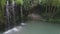 Woman hiker traveler looking at beautiful waterfall with blue lake