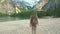 Woman hiker walking around the Braies lake and enjoys his spectacular sceneries, Dolomites, Italy