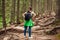 Woman hiker walking through mountain forest path surrounded with roots in Carpathians. Traveler with backpack resting