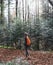 Woman hiker walking on the trail in mysterious woods. Back view.